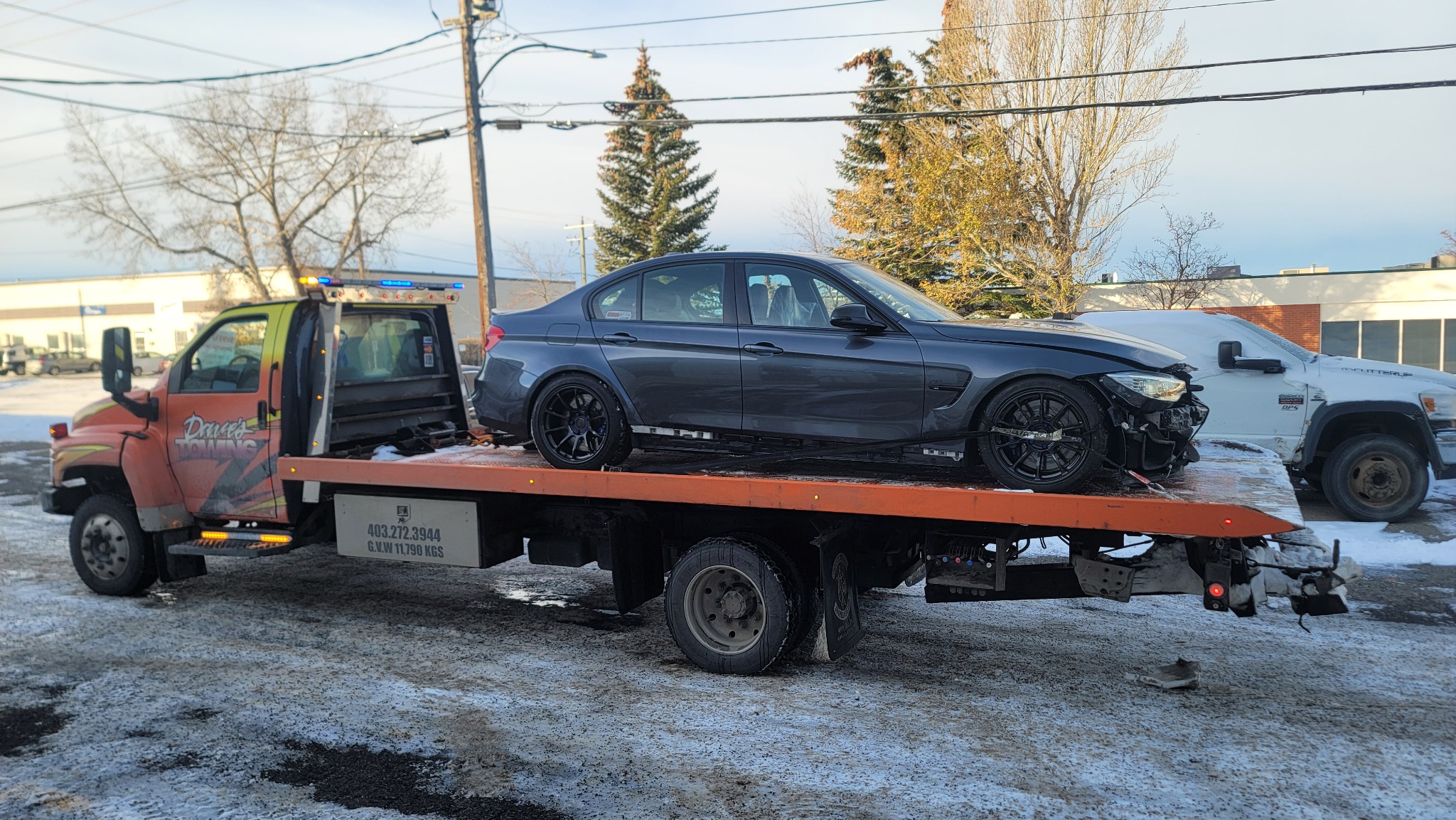 Flatbed tow truck loading a performance car in winter